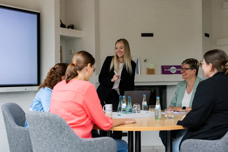 Teamarbeit und Weiterbildung bei Steuerberater RKK – Gemeinsam für beste Beratungsqualität Mitarbeiterin der Kanzlei RKK präsentiert dem Team an einem großen Bildschirm im Besprechungsraum